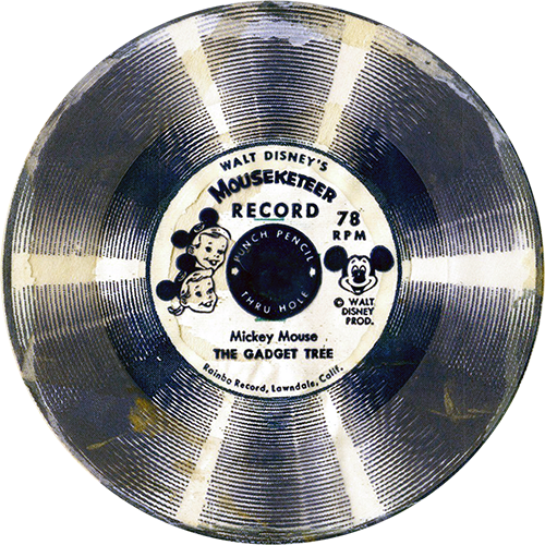 This image is of a vintage Walt Disney’s Mouseketeer Record, a 78 RPM flexi-disc. The label in the center features drawings of a boy and a girl wearing Mickey Mouse ear hats, representing Mouseketeers, and includes a picture of Mickey Mouse. The title of this record is "The Gadget Tree," attributed to Mickey Mouse. The record itself has a circular design with alternating light and dark bands, creating a striped appearance. The label mentions "Punch Pencil Thru Holes" and indicates that it was produced by "Rainbo Records, Lawndale, Calif." This record, like the others, is designed for children to punch through the center for use, likely in a children's phonograph or similar device.
