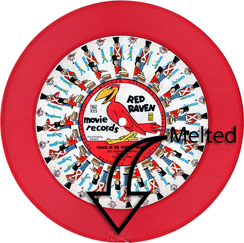 The image shows a Red Raven Movie Record titled "Parade of the Wooden Soldiers." The record features the iconic Red Raven logo in the center, with colorful illustrations of toy soldiers marching around the edge, intended to animate when viewed with a Red Raven Magic Mirror. The record is red in color, but there is noticeable damage near the bottom, where the vinyl has melted, distorting the surface. The word "Melted" is superimposed over the damaged area with an arrow pointing to the melted section, highlighting the damage to the record. Despite the damage, the illustrations and label details remain visible, showing the vibrant design typical of Red Raven Movie Records.