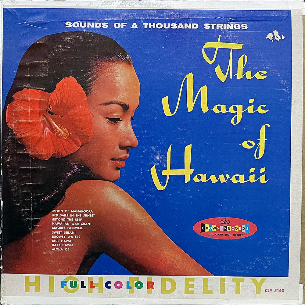 A vintage record sleeve titled The Magic of Hawaii by "Sounds of a Thousand Strings," released on Crown Records (CLP 5163). The cover features a profile of a woman with long dark hair adorned with a large red hibiscus flower, set against a bright blue background. The album title is written in yellow stylized script. A track list is printed in small white font on the woman's back and shoulder, including “Moon of Manakoora,” “Sweet Leilani,” and “Aloha Oe.” The bottom banner reads “FULL COLOR HIGH FIDELITY” in rainbow and gold lettering.